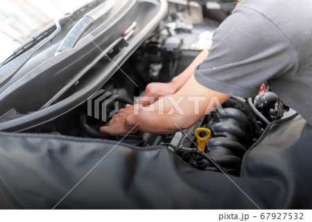 Car mechanic working on engine repair 67927532