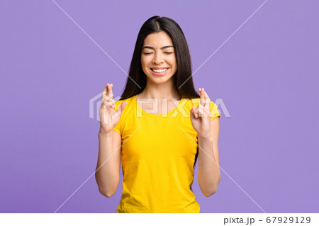 Making A Wish. Smiling Asian Woman Crossing Fingers With Closed Eyes Making A Wish. Smiling Asian Woman Crossing Fingers With Closed Eyes 67929129