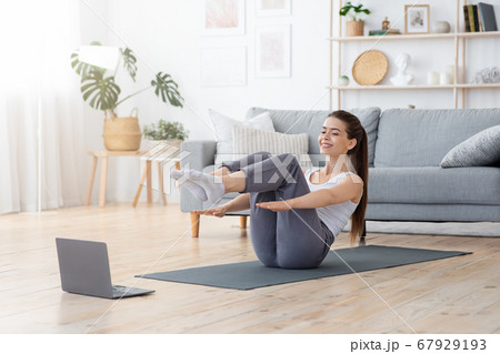 Energetic young lady having workout at home 67929193