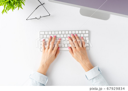 Woman hands working on computer with accessories on white background. Office desktop. Top view Woman hands working on computer with accessories on white background. Office desktop. Top view 67929834