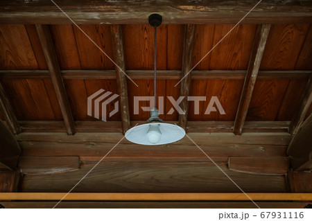 木造家屋から吊るされた古典的な明かり（ガラスの笠と電球） 67931116