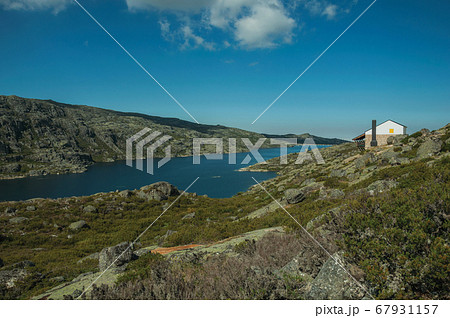 Rocky landscape with lake and house on highlands Rocky landscape with lake and house on highlands 67931157