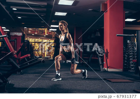 Beautiful young sporty woman training, workout in gym 67931377