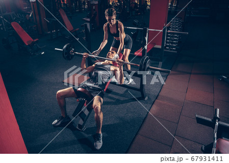 Beautiful young sporty couple training, workout in gym together Beautiful young sporty couple training, workout in gym together 67931411