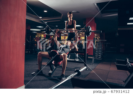 Beautiful young sporty couple training, workout in gym together Beautiful young sporty couple training, workout in gym together 67931412