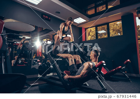 Beautiful young sporty couple training, workout in gym together 67931446
