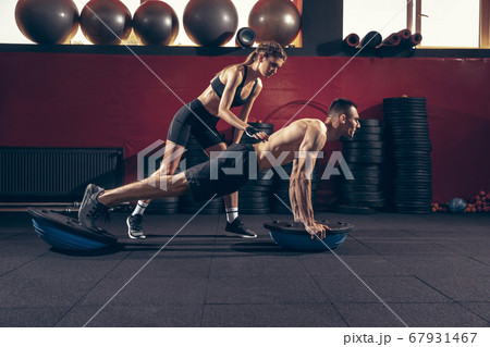 Beautiful young sporty couple training, workout in gym together 67931467