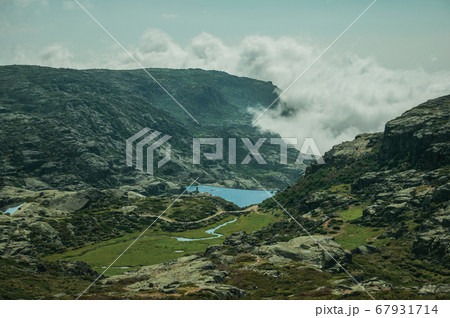 Hilly landscape with clouds coming from the ravine Hilly landscape with clouds coming from the ravine 67931714
