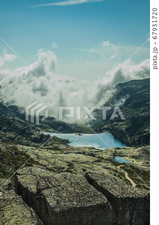 Hilly landscape with clouds coming from the ravine Hilly landscape with clouds coming from the ravine 67931720