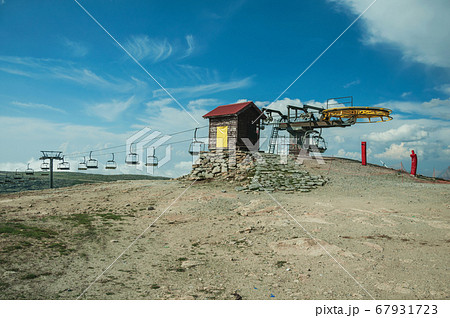 Hilly landscape with chairlift mechanism and towers 67931723