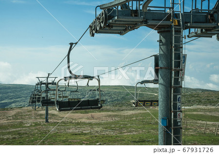 Chairlift towers and cables over hilly landscape Chairlift towers and cables over hilly landscape 67931726