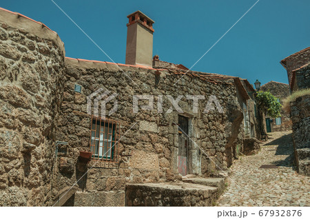 Old houses with stone wall in alley on slope at Monsanto Old houses with stone wall in alley on slope at Monsanto 67932876