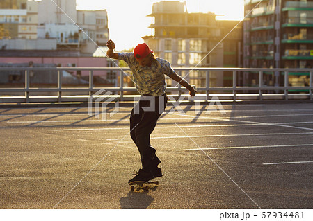 Skateboarder doing a trick at the city's street in summer's sunshine 67934481