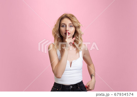 Caucasian young woman's portrait isolated on pink studio background. Beautiful female model. Concept of human emotions, facial expression, sales, ad, youth culture. Caucasian young woman's portrait isolated on pink studio background. Beautiful female model. Concept of human emotions, facial expression, sales, ad, youth culture. 67934574