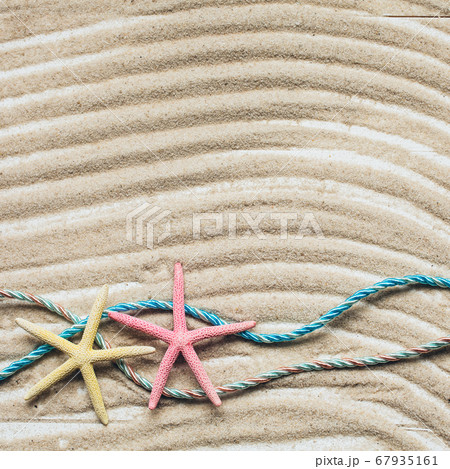 Holiday summer background. Colored starfish on sandy beach. Top view with copy space. Holiday summer background. Colored starfish on sandy beach. Top view with copy space. 67935161