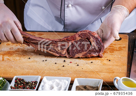 The chef prepares meat steak in his hands The chef prepares meat steak in his hands 67935436
