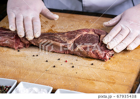 The chef prepares meat steak in his hands The chef prepares meat steak in his hands 67935438