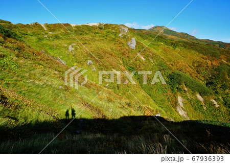 飯豊山の稜線に立つ登山者の影 67936393