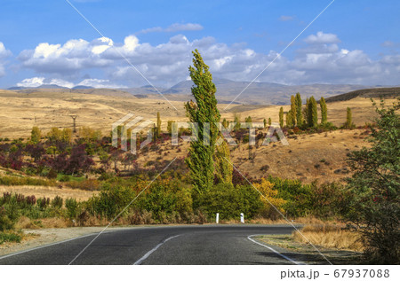 Autumn day with a turn on the highway passing through the foothills of the Geghama ridge and leading to the monastery of Geghard in Armenia Autumn day with a turn on the highway passing through the foothills of the Geghama ridge and leading to the monastery of Geghard in Armenia 67937088