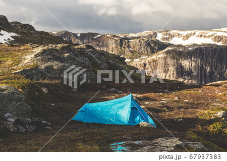 Tourist's tent stands in the mountains. Summer sunrise above beautiful rocks in Norway. Tourist's tent stands in the mountains. Summer sunrise above beautiful rocks in Norway. 67937383