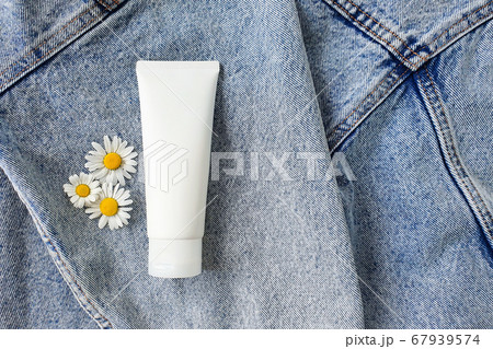 Cosmetics spa branding mock-up with camomile flowers on a denim background. Natural organic cosmetic packaging mock up. Top view, flower flatlay. Cosmetics spa branding mock-up with camomile flowers on a denim background. Natural organic cosmetic packaging mock up. Top view, flower flatlay. 67939574