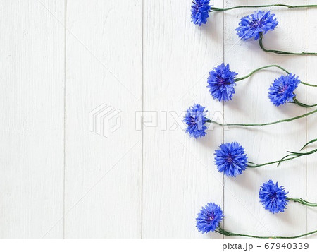 Top view of flower border of blue cornflowers on a shabby white wooden background. Floral line, flat lay, horizontal photo. 67940339