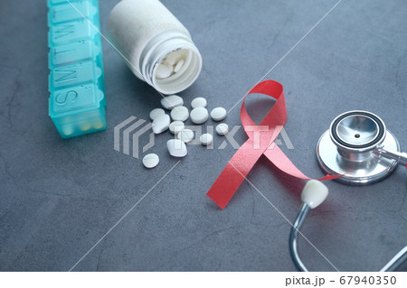 Red ribbon HIV, pills and stethoscope on black background. Red ribbon HIV, pills and stethoscope on black background. 67940350