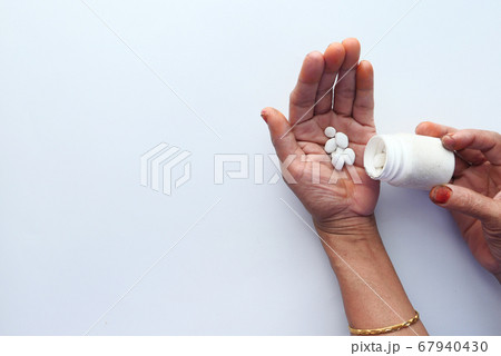 top view of senior women taking pills top view of senior women taking pills 67940430