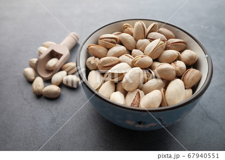 Pistachios nut in a bowl on gray background  67940551