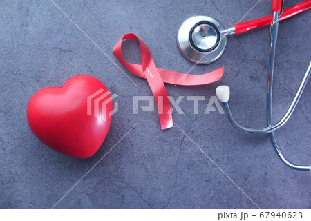 Red ribbon HIV, heart and stethoscope on black background. 67940623
