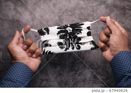 Hand holding homemade protective face Mask, top view  67940626