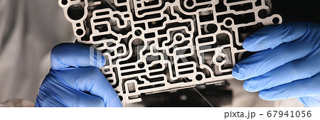 Male specialist examines valve body Male specialist examines valve body 67941056