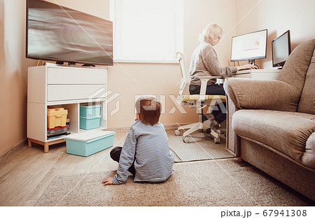 woman working at home with little child. woman working at home with little child. 67941308