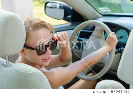 Woman driving a car 67941450