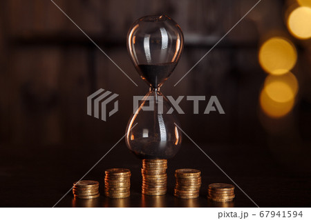 Hourglass with stack of coins. Time is money, investment concept Hourglass with stack of coins. Time is money, investment concept 67941594