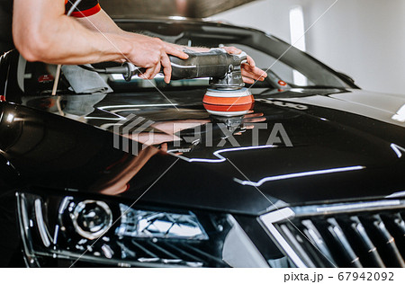 Professional detailing a car in car studio, hands with orbital polisher, scratching remover, vehicle care concept 67942092