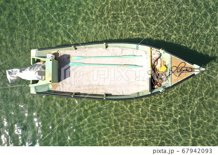 Small Fishing Boat anchored in a shallow lagoon. 67942093