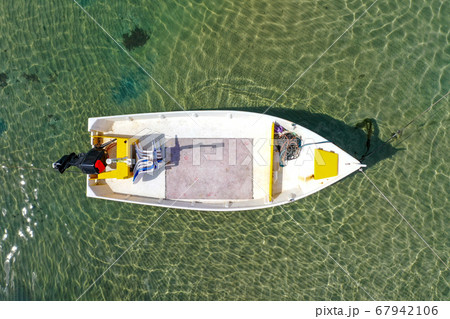 Small Fishing Boat anchored in a shallow lagoon. 67942106