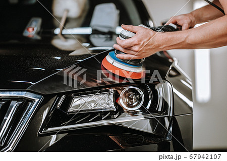 Professional detailing a car in car studio, hands with orbital polisher, scratching remover, vehicle care concept 67942107