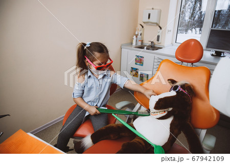 Little dentist treating toy patient 67942109