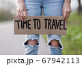 Girl holds cardboard plate with inscription words Time to travel 67942113