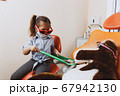 Little dentist examining teeth of toy 67942130