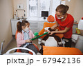 Little girl and dentist brushing teeth of toy 67942136