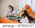 Little dentist brushing teeth of toy 67942157