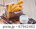 fried cheese sticks with sour cream sauce on a wooden table 67942462