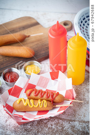 corn dog with ketchup and yellow mustard corn dog with ketchup and yellow mustard 67942688