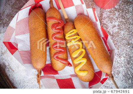 corn dog with ketchup and yellow mustard corn dog with ketchup and yellow mustard 67942691