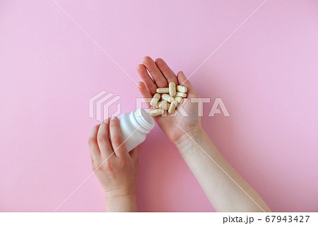 White pill packaging on pink background.  67943427