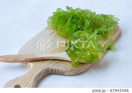 fresh green leaves of Ulva seaweed, for making salad, on a wooden Board, light background 67943566