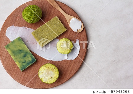 Two pieces of natural osage orange fruit scrub soap for Spa treatments, and an Adam Apple fruit, top view on a light background 67943568